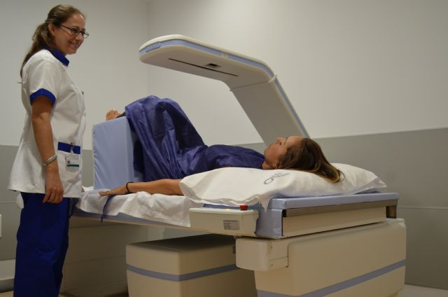 Una paciente en la consulta de radiología realizándose una densitometría, Foto 1