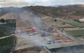 Helicóptero de la DGSCyE y bomberos del Consorcio trabajan en la extinción del incendio en una granja en Totana