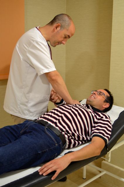 Pablo López, responsable de la Unidad de Fisioterapia y Rehabilitación de Hospital La Vega, tratando a un paciente, Foto 1